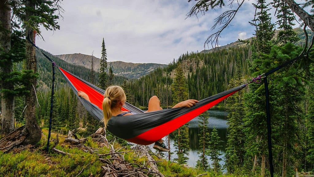 A woman lies in a hammock in the forest. What a way to spend a restful weekend!