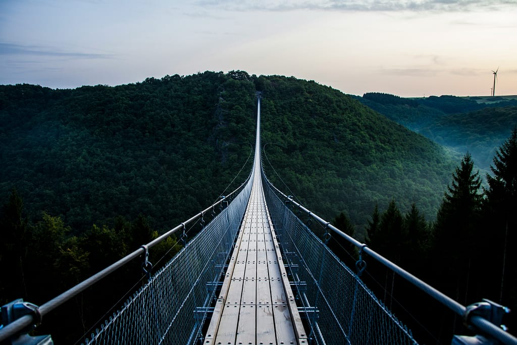 A narrow suspension bridge stretches across a ravine. It looks a little wobbly, but worth the effort. A bit like confidence in midlife - it can get a little wobbly.