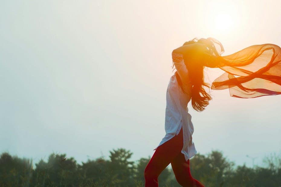 A woman runs with a scarf flying behind her.