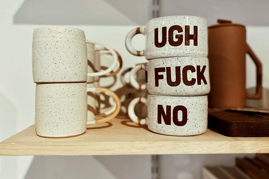 cups on a shelf say "ugh f*ck no"