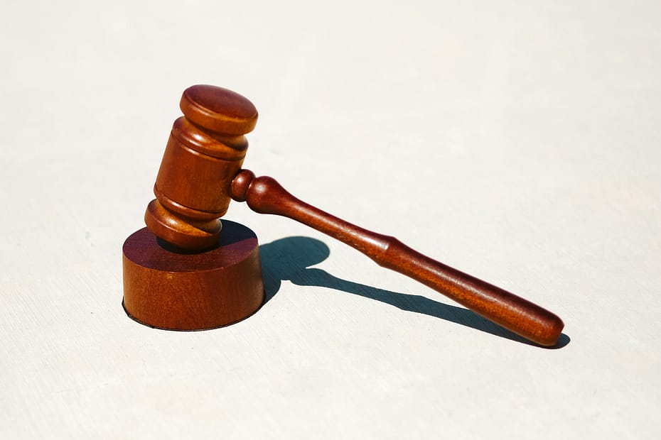 A wooden gavel rests against a pale background.